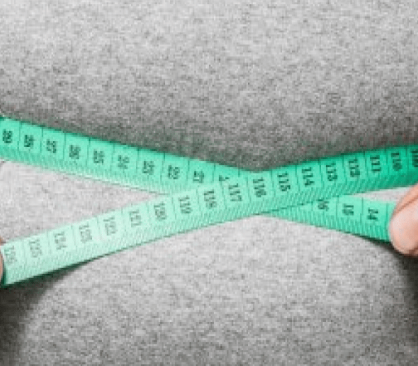 A person using measuring tape to measure their waist